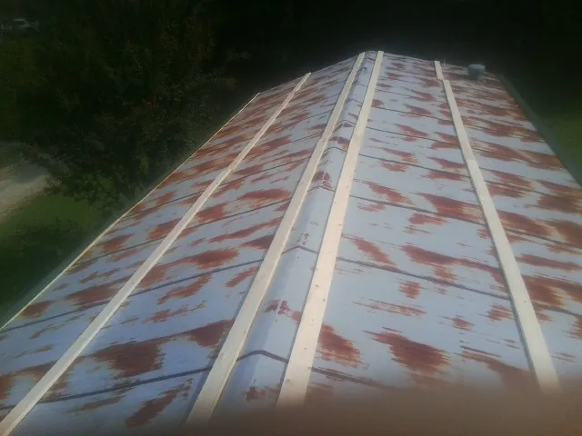 Rusted metal roof panels with new wood purlins before replacement — Storm Damage Roof Repair in Wixom by Roofing Brothers