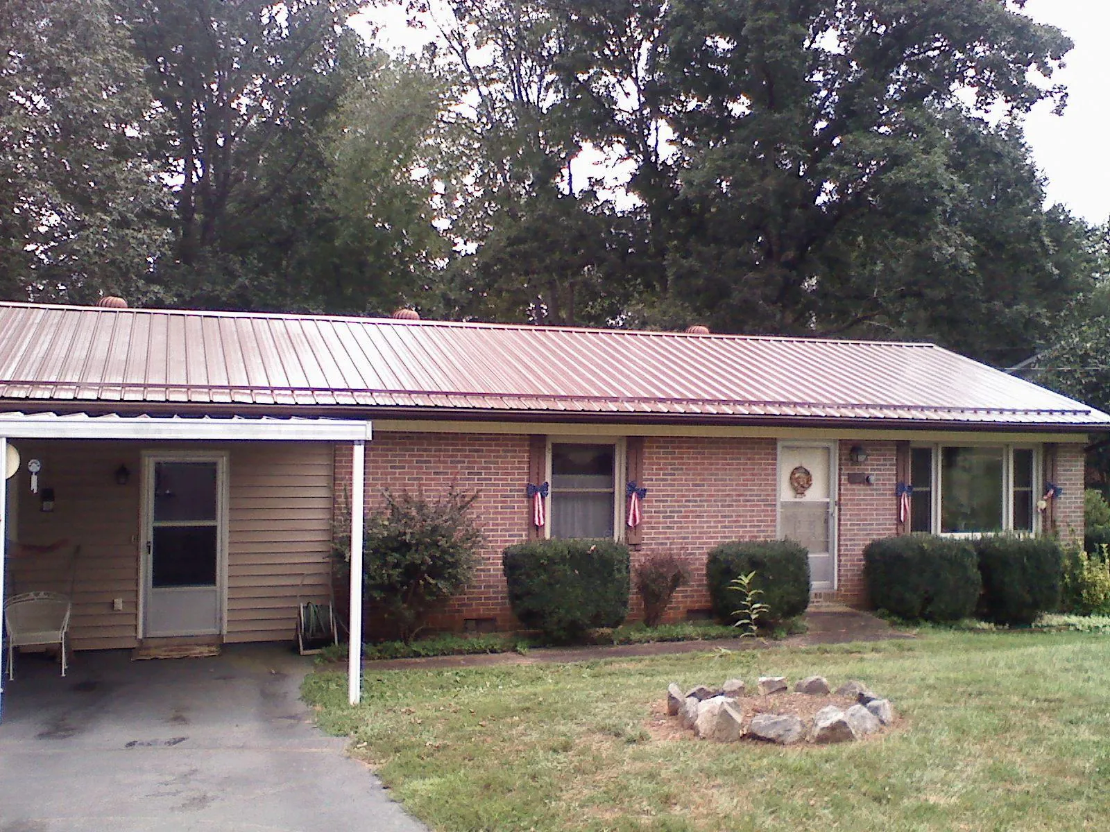 Bronze metal roof and carport on a brick ranch home — Roof Repair work by our crew in Wixom