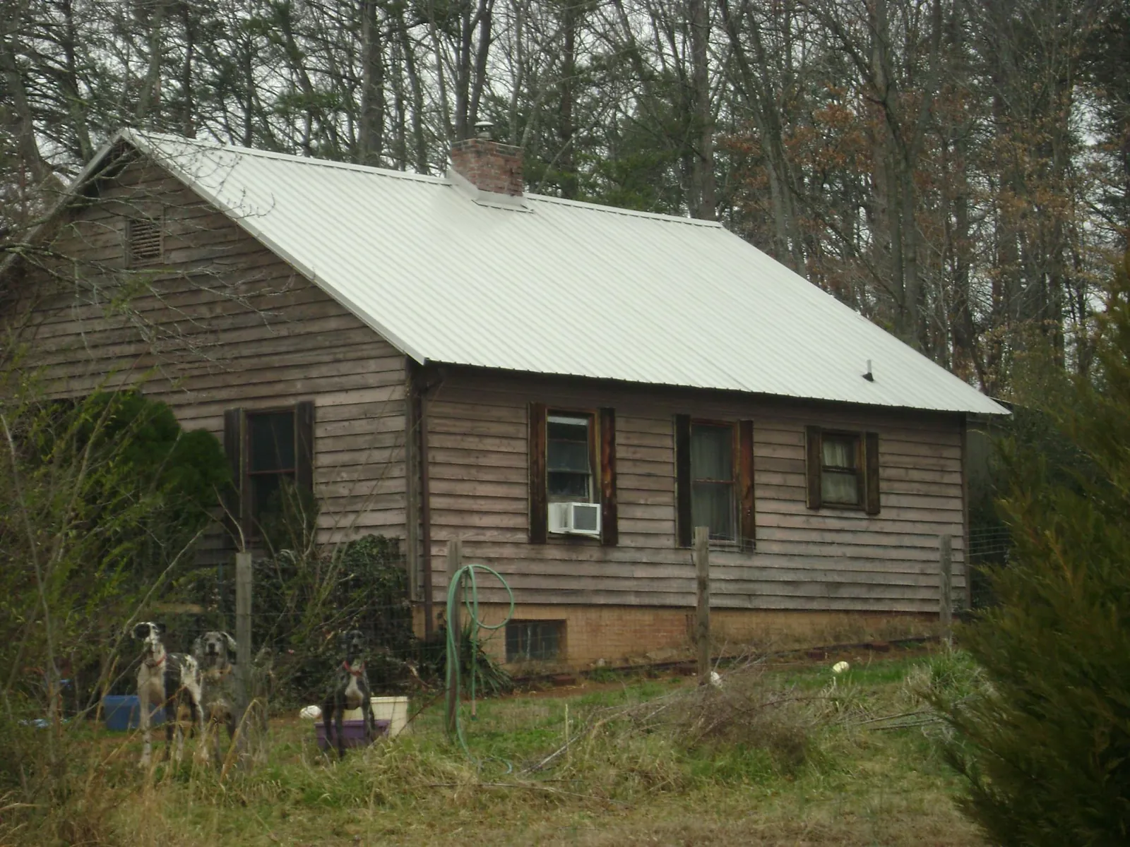White metal roof on an old wood sided farmhouse, from a Metal Roof Installation job in Wixom